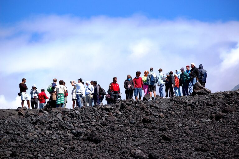 Gruppo di escursionisti con giacche e zaini sul terreno di lapilli neri dell'Etna